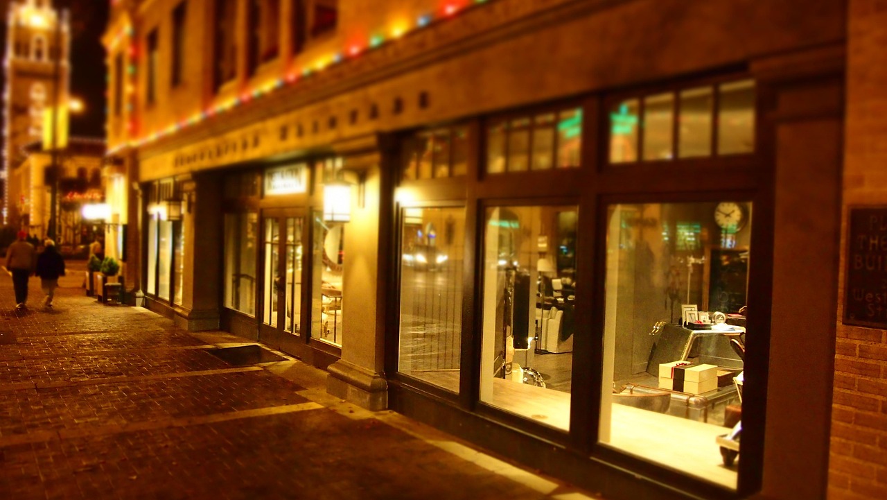 Vitrines de commerces éclairées dans une rue en soirée