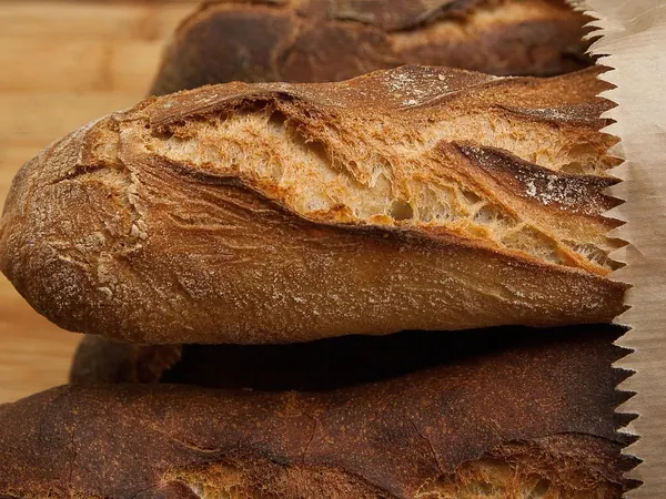Des baguettes de pain dans leur sachet en papier