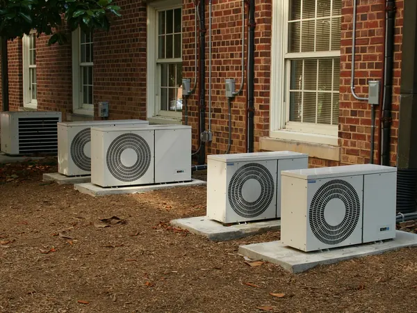 Deux unités extérieures de climatisation fixées sur un mur de briques, Chauffage et climatisation.