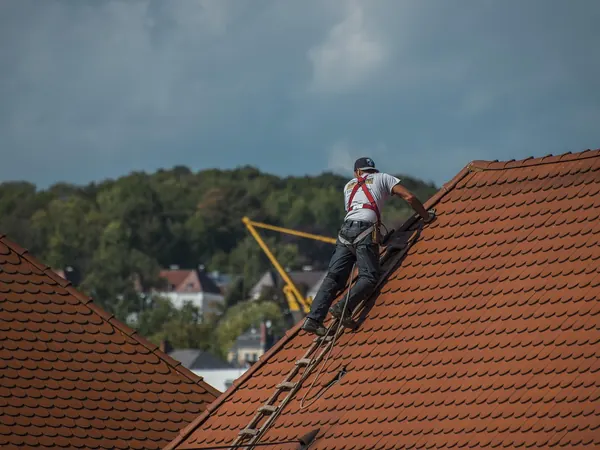 Un couvreur en harnais sur un toit de tuiles, Couvreurs.