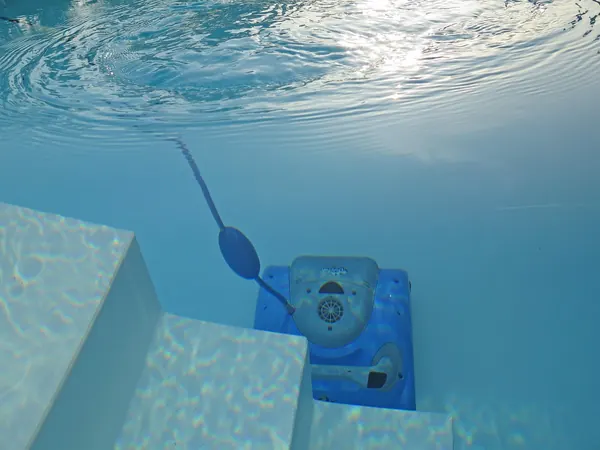 Une épuisette de nettoyage sous la surface d'une piscine, Nettoyage de piscines.