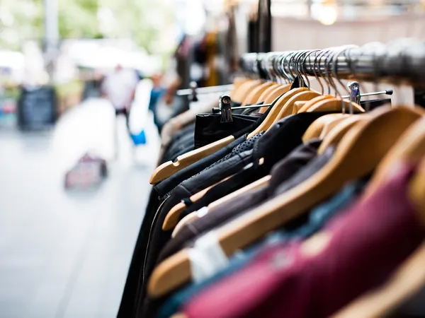 Un portant de vêtements à l'entrée d'une boutique, prêt-à-porter